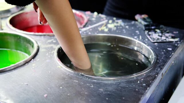 The child slowly lowers his hand into a bowl of water to cool down