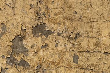 Fototapeta premium Layers of peeling paint and cracks showcase the rich history and texture of a weathered wall in a forgotten space.