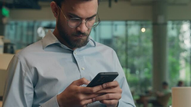 Arabian man ethnic guy upset worried frustrated businessman male business employer worker freelancer visitor reading mobile phone screen receive bad message cellphone notification sad anxious in cafe