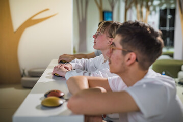 Three friends, teenagers having fun playing a quiz game visiting an amusing interactive natural history museum. Education and entertainment concepts.