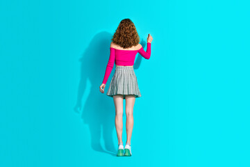 Full body rear portrait of nice young girl empty space board wear top isolated on turquoise color background