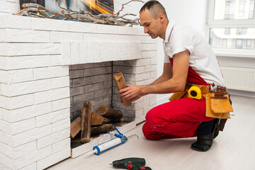 Professional technician installing electric fireplace in room