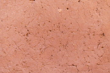 Red clay textured wall, cracked and aged ancient building.
