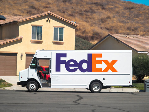 Lake Elsinore, CA, USA - September 25, 2024: FedEx delivery truck delivering packages to a home on a residential street