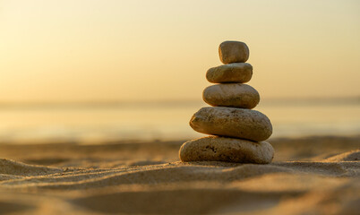 Zen stones background. Pyramid of stones on the background of sunset on the sea beach. Relax, balance, calm, concept.