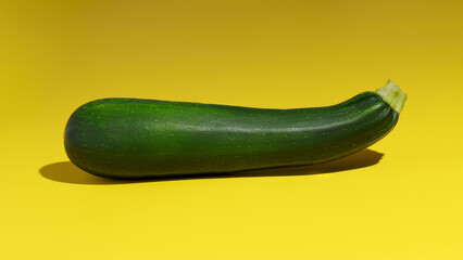 Ripe green squash on a yellow background. The concept of fresh food.