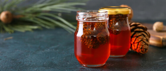 Jars of tasty pine cone jam on dark background