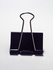 Black metal paperclip on a white background