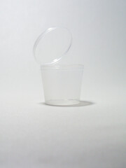 Transparent small plastic container with fliptop lid on white background, perfect for keeping small things in bag