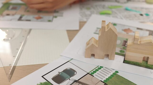 Smart architect and safety engineer discussion about building blueprint on table with architectural document, measurement tools and wooden block scatter around at modern office. Closeup. Delineation.