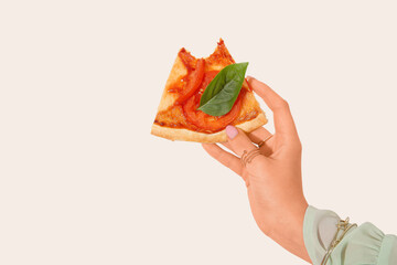Woman holding slice of bitten pizza on white background