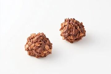 Two chocolate dipped oat energy balls with a crispy texture on a plain white background