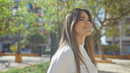 A smiling young woman enjoys a sunlit urban park setting, embodying both beauty and serenity.