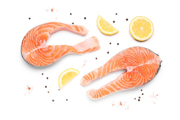 Raw salmon steaks with lemon and peppercorn on white background