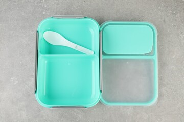 Empty plastic lunch box with cutlery on light grey table, top view