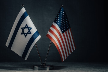 Table flag of United States America and Israel on dark background. Cooperation between two...