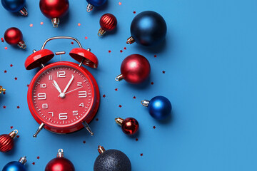 Alarm clock and Christmas decor on blue background