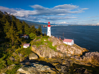 Aerial view of a light house near Vancouver shore during sunset with blue sky