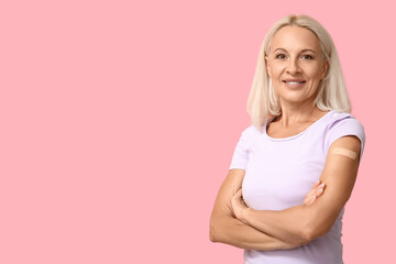 Mature woman with medical patch on arm against pink background. Vaccination concept