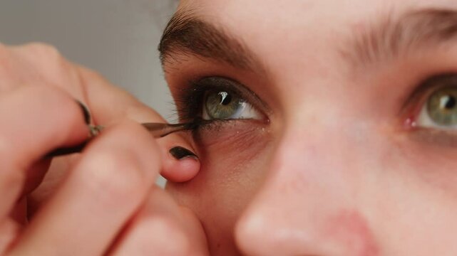 Eye shadow makeup to the upper eyelid, close-up. Makeup artist applies a bright eye shadow with a make-up brush.Tutorial master class of professional makeup, smoky eyes 