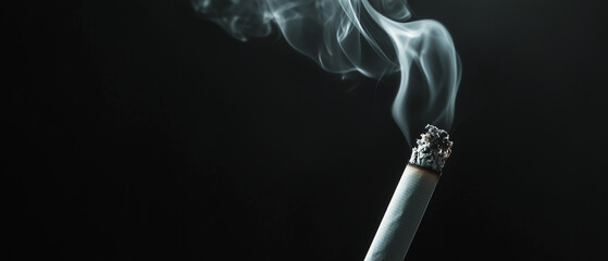 Against a dark background, a smouldering cigarette emits a faint red light, the smoke slowly rising upwards, dissolving into the surrounding darkness
