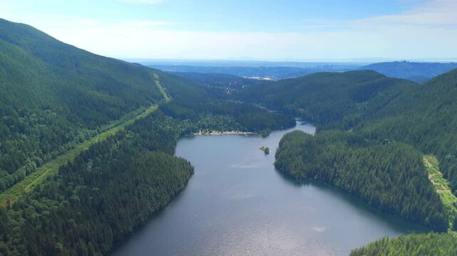 Birds view of a park with a lake and mountains at the distance near Vancouver