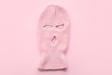 Knitted balaclava on pink background