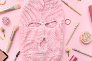 Composition with balaclava, accessories and cosmetics on pink background, closeup