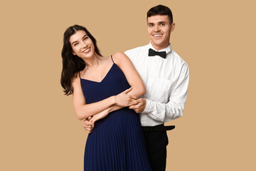 Happy young couple dancing on brown background