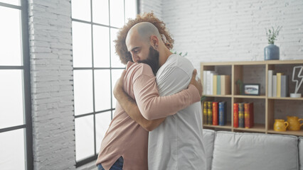 Fototapeta premium Two men embracing in a loving hug inside a cozy living room with modern decor, expressing friendship or relationship.