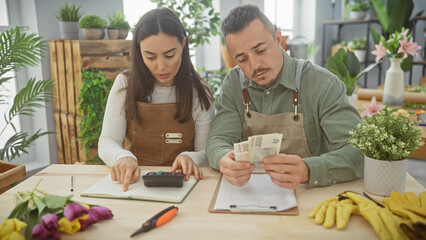 A woman and man calculate finances with czech koruna in a flower shop filled with plants and bouquets.