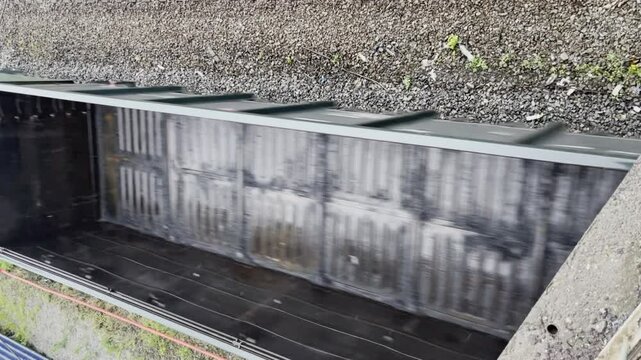 Vertical video of empty rail cars moving on railway in summer