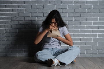 Young African-American woman having panic attack in room