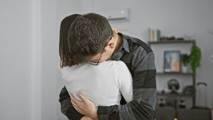 Obraz premium A man and woman embrace lovingly in a cozy living room, evoking a sense of comfort, relationship, and togetherness.