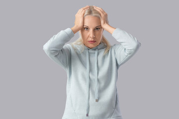 Mature woman having panic attack on light background