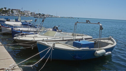 Porto cesareo in puglia, italy, showcasing boats docked in a serene harbor under a clear blue sky.