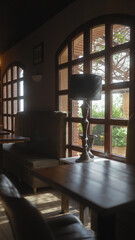 Cozy interior scene with natural light, showcasing a lamp, couch, wooden table, and arch windows.