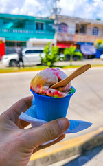 Colorful fruit ice cream in a cup in your hand.