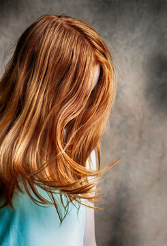 Mysterious spooky image of anonymous little girl with bright red hair.