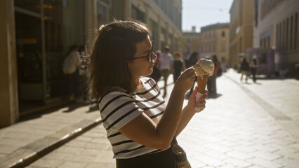 Young hispanic woman enjoying gelato in the beautiful town of lecce, puglia, italy, highlighting her casual outfit and the charming european street setting.