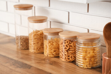 Glass jars with different products on counter in kitchen