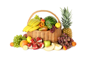 Many different fresh fruits in wicker basket isolated on white