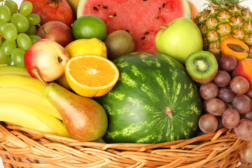 Many different fresh fruits in wicker basket, closeup