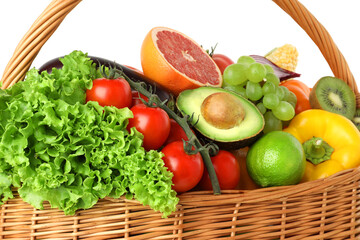 Different fresh vegetables and fruits in wicker basket isolated on white