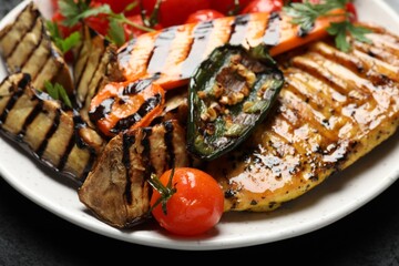 Delicious grilled vegetables and chicken breast on table, closeup