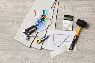 Tools, calculator, house project, color palettes and laminate boards on floor