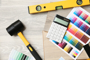 Tools, calculator, color palettes and laminate boards on floor