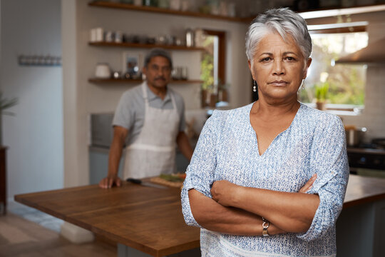 Mature woman, frustrated and crossed arms in house for fight, argument and marriage conflict with partner. Female person, angry and unhappy in kitchen for pride, disappointed and cooking disagreement