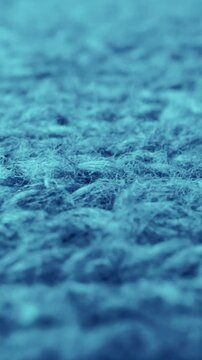 Extreme detail view of sheep wool cloth texture in macro dolly shot. Flowing animal fiber material for handcraft knitting. Textile abstract background. Winter fashion clothing industry concept.