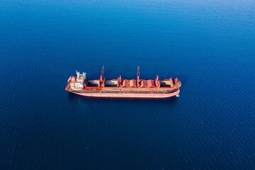 Bulk dry cargo carrier ship at anchorage preparing ship holds for new cargo freight. Aerial view